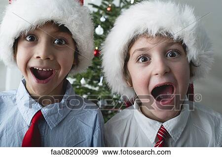 Boys wearing Santa hats, portrait View Large Photo Image Stock Photo - Boys wearing Santa hats, portrait. Fotosearch