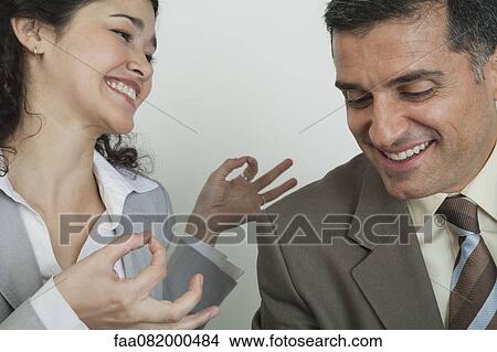 Business associates laughing together, woman holding hands in mudra View Large Photo Image Picture - Business associates laughing together, woman holding hands in mudra. Fotosearch