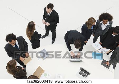 Business associates working together in small groups around table View Large Photo Image Stock Photo - Business associates working together in small groups around table. Fotosearch