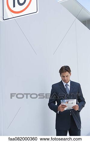 Businessman reading newspaper outdoors View Large Photo Image Stock Image - Businessman reading newspaper outdoors. Fotosearch