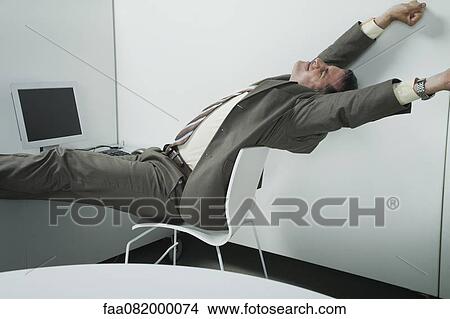Businessman stretching at desk View Large Photo Image Picture - Businessman stretching at desk. Fotosearch