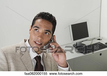 Businessman using cell phone in office View Large Photo Image Stock Photography - Businessman using cell phone in office. Fotosearch