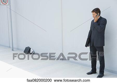 Businessman using cell phone outdoors View Large Photo Image Stock Image - Businessman using cell phone outdoors. Fotosearch