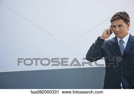 Businessman using cell phone outdoors View Large Photo Image Stock Image - Businessman using cell phone outdoors. Fotosearch
