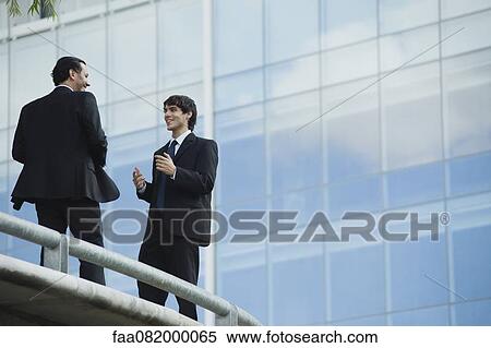 Businessmen talking together outdoors View Large Photo Image Stock Photography - Businessmen talking together outdoors. Fotosearch