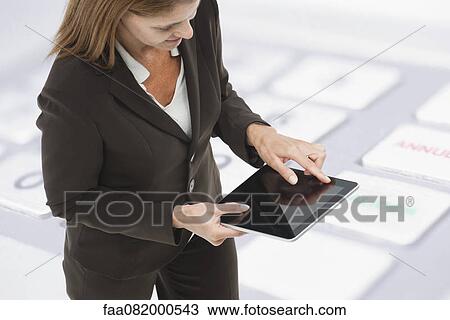 Businesswoman using digital tablet, close-up image of keyboard superimposed on background View Large Photo Image Stock Image - Businesswoman using digital tablet, close-up image of keyboard superimposed on background. Fotosearch