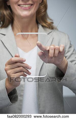 Businesswoman using transparent digital tablet View Large Photo Image Stock Image - Businesswoman using transparent digital tablet. Fotosearch