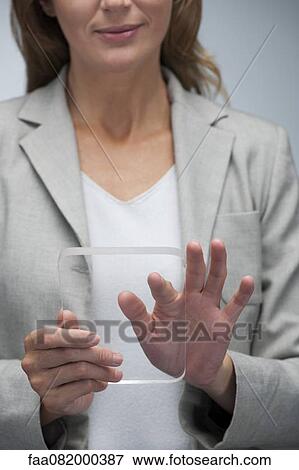 Stock Photo - Businesswoman using transparent digital tablet. Fotosearch