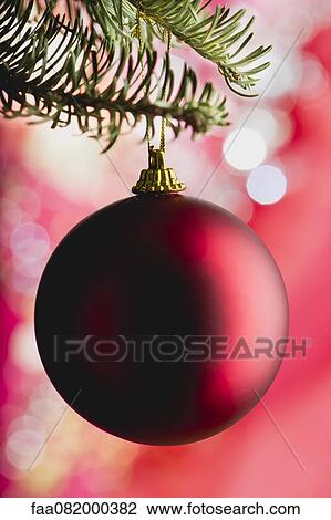 Stock Image - Christmas bauble hanging on branch. Fotosearch