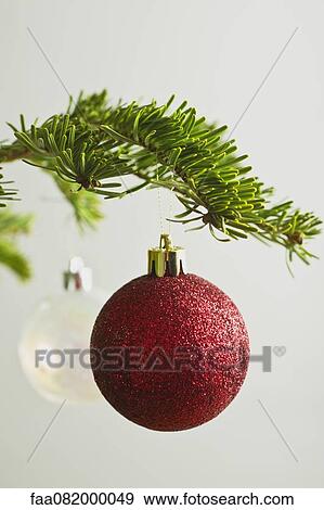 Stock Photo - Christmas baubles hanging from Christmas tree. Fotosearch