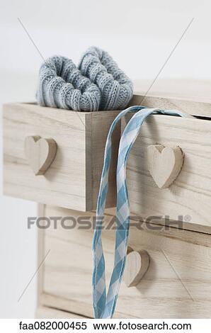 Stock Photography - Clothing hanging out of wooden drawers with heart shaped knobs. Fotosearch