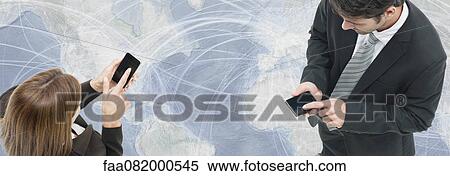 Colleagues exchanging information with smartphones, world map in background View Large Photo Image Stock Photography - Colleagues exchanging information with smartphones, world map in background. Fotosearch