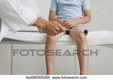Doctor checking boy's reflexes with reflex hammer, cropped View Large Photo Image Picture - Doctor checking boy's reflexes with reflex hammer, cropped. Fotosearch