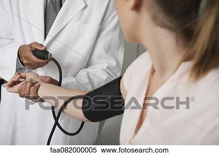 Doctor checking patient's blood pressure, cropped View Large Photo Image Stock Photography - Doctor checking patient's blood pressure, cropped. Fotosearch