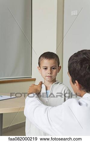 Doctor comforting little boy View Large Photo Image Stock Photo - Doctor comforting little boy. Fotosearch
