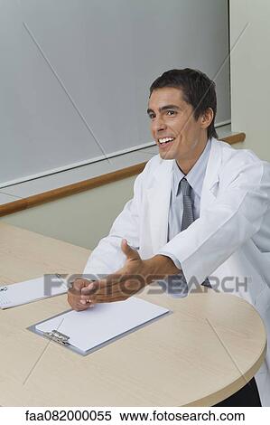 Stock Photography - Doctor greeting patient in office. Fotosearch