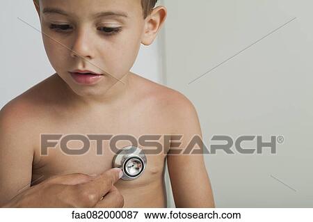Doctor listening to boy's chest with stethoscope, cropped View Large Photo Image Stock Photo - Doctor listening to boy's chest with stethoscope, cropped. Fotosearch