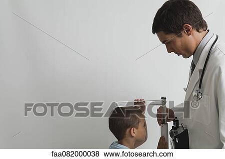 Doctor measuring little boy during check-up View Large Photo Image Stock Photo - Doctor measuring little boy during check-up. Fotosearch