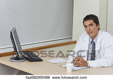 Stock Photo - Doctor sitting in office. Fotosearch