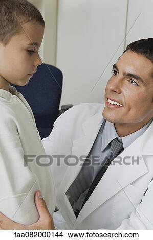 Doctor smiling at little boy View Large Photo Image Picture - Doctor smiling at little boy. Fotosearch