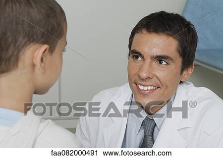 Doctor smiling at little boy View Large Photo Image Stock Image - Doctor smiling at little boy. Fotosearch