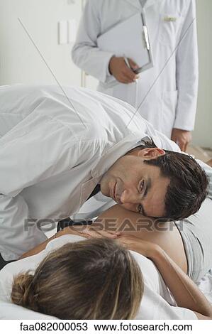 Doctor with ear against pregnant woman's abdomen View Large Photo Image Stock Image - Doctor with ear against pregnant woman's abdomen. Fotosearch