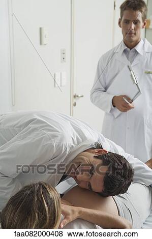 Doctor with ear against pregnant woman's abdomen View Large Photo Image Stock Photo - Doctor with ear against pregnant woman's abdomen. Fotosearch