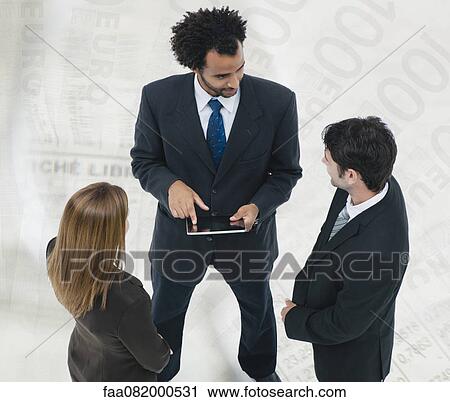 Stock Image - Executives talking together with one-hundred Euro banknotes superimposed on background. Fotosearch