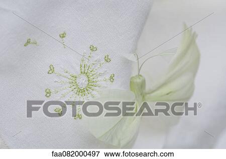 Stock Photo - Fake butterfly resting on embroidered fabric. Fotosearch
