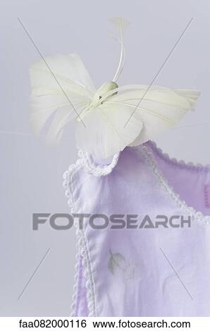 Stock Photograph - Fake butterfly resting on shoulder of baby clothing. Fotosearch