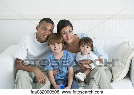 Stock Photo - Family sitting together on sofa, portrait. Fotosearch
