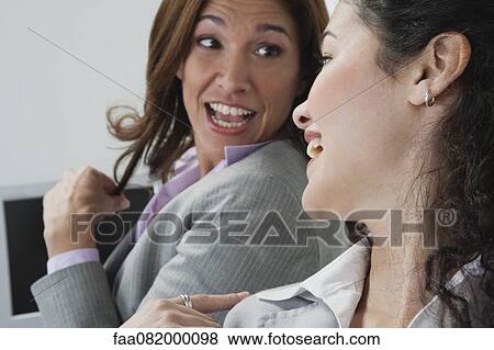 Female coworkers chatting in office View Large Photo Image Stock Photo - Female coworkers chatting in office. Fotosearch