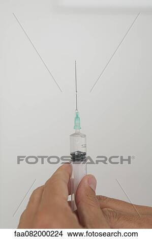 Picture - Hand holding syringe. Fotosearch