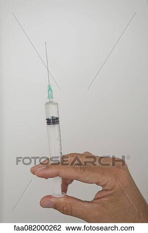 Hand holding syringe View Large Photo Image Stock Image - Hand holding syringe. Fotosearch