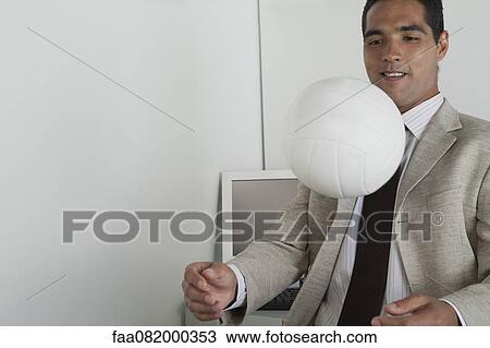 Man playing with ball in office View Large Photo Image Stock Image - Man playing with ball in office. Fotosearch
