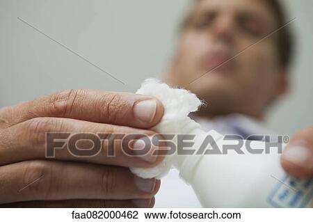 Man pouring antiseptic on cotton ball View Large Photo Image Stock Image - Man pouring antiseptic on cotton ball. Fotosearch