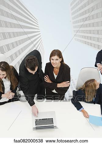Mature businesswoman meeting with colleagues, skyscrapers superimposed on background View Large Photo Image Stock Photo - Mature businesswoman meeting with colleagues, skyscrapers superimposed on background. Fotosearch