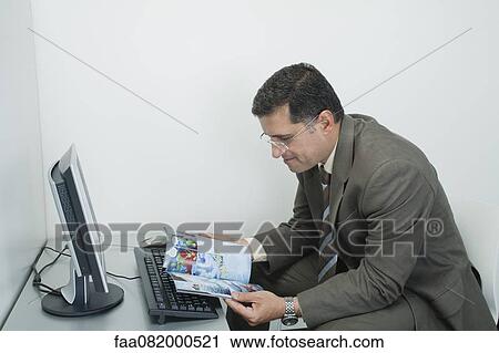 Mature man reading comic book in office cubicle View Large Photo Image Stock Image - Mature man reading comic book in office cubicle. Fotosearch