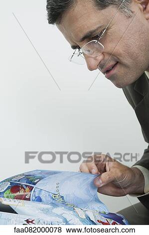 Mature man reading comic book View Large Photo Image Stock Photo - Mature man reading comic book. Fotosearch