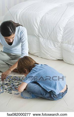 Mother and son completing jigsaw puzzle View Large Photo Image Stock Photo - Mother and son completing jigsaw puzzle. Fotosearch