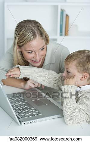 Mother and son using laptop computer together View Large Photo Image Stock Photo - Mother and son using laptop computer together. Fotosearch