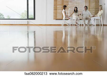 Stock Image - Patients holding hands during group therapy session. Fotosearch