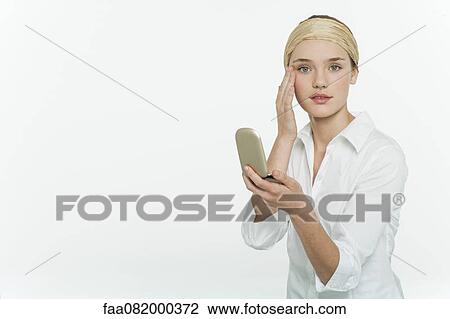 Preteen girl holding mirror compact, touching face, portrait View Large Photo Image Stock Image - Preteen girl holding mirror compact, touching face, portrait. Fotosearch