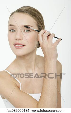 Stock Photography - Preteen girl using eyebrow brush. Fotosearch