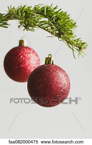 Stock Photography - Red Christmas baubles handing from Christmas tree. Fotosearch