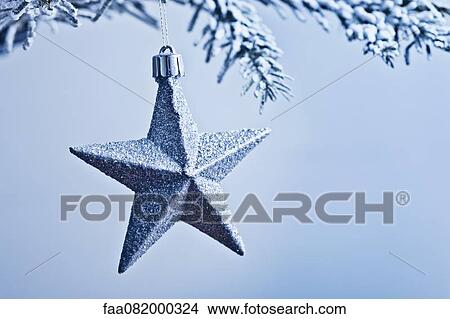 Star-shaped Christmas ornament hanging from branch View Large Photo Image Picture - Star-shaped Christmas ornament hanging from branch. Fotosearch