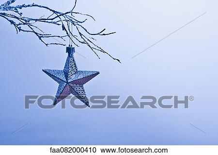 Star-shaped Christmas ornament hanging from branch View Large Photo Image Stock Image - Star-shaped Christmas ornament hanging from branch. Fotosearch