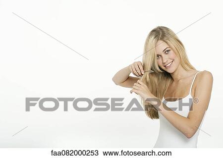 Stock Image - Teen girl combing her hair. Fotosearch