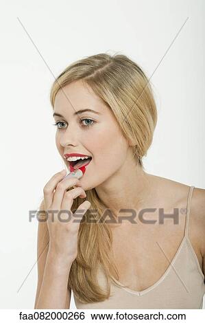 Teen girl putting on lipstick View Large Photo Image Stock Photograph - Teen girl putting on lipstick. Fotosearch