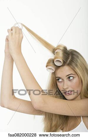 Stock Photo - Teen girl rolling her hair with curlers. Fotosearch